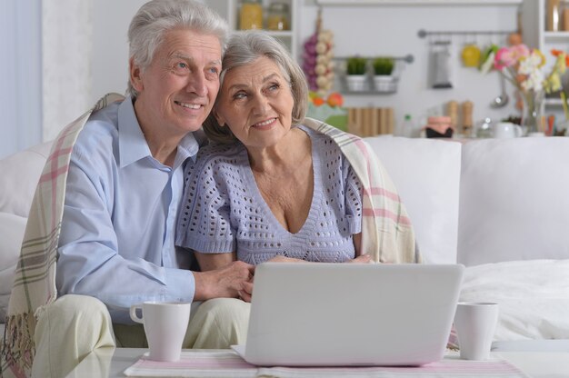 Felice coppia di anziani con il portatile a casa