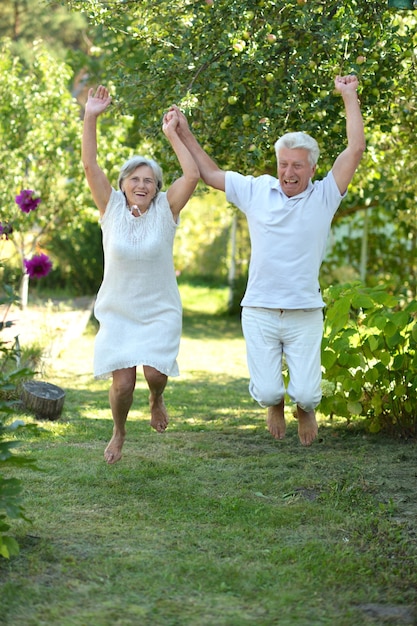 Felice coppia di anziani divertendosi nel parco di tarda primavera
