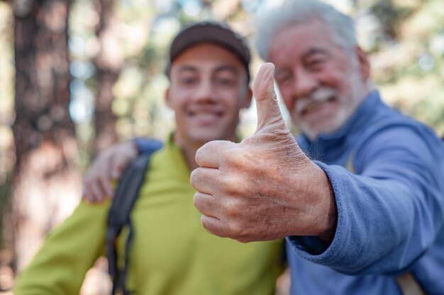 Felice coppia di nonno anziano e giovane nipote che fa un'escursione insieme nei boschi condividendo la stessa passione per la natura e lo stile di vita sano