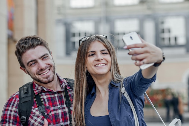 Felice coppia di turisti che prendono selfie nella vetrina della città