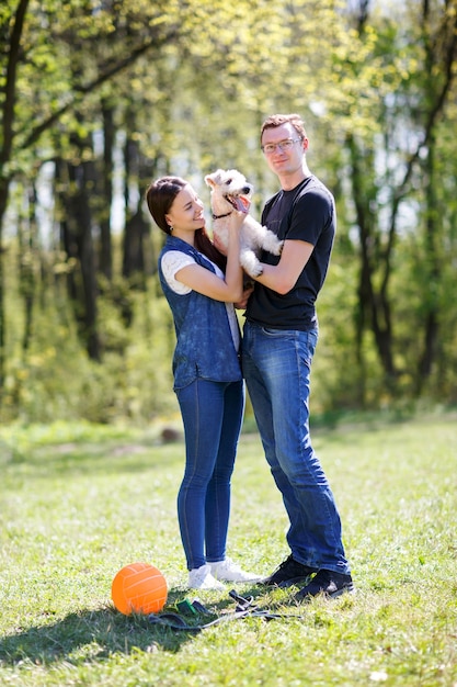 Felice coppia giovane e il loro cane al parco