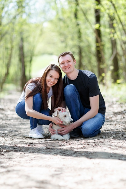 Felice coppia giovane e il loro cane al parco