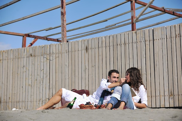 felice coppia giovane godendo picnic sulla spiaggia e divertirsi durante le vacanze estive