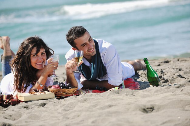 felice coppia giovane godendo picnic sulla spiaggia e divertirsi durante le vacanze estive