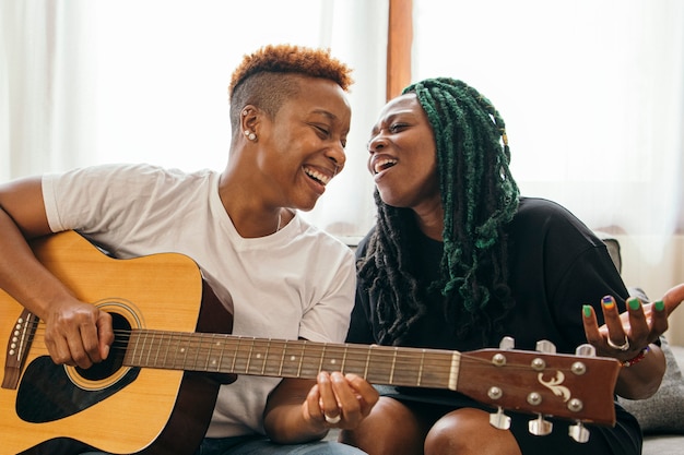 Felice coppia lesbica che suona la chitarra e canta