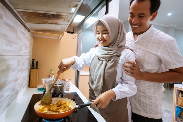 Felice coppia musulmana cucinare insieme in cucina. uomo e donna che si preparano per la cena