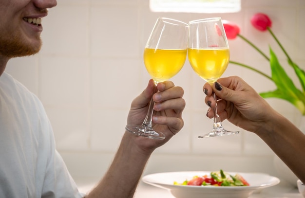 Felice coppia romantica che celebra con bicchieri di vino in cucina a casa