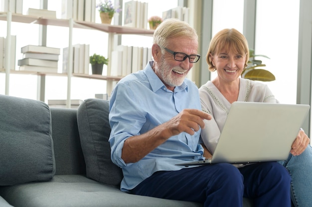 Felice coppia senior caucasica che utilizza il computer portatile a casa