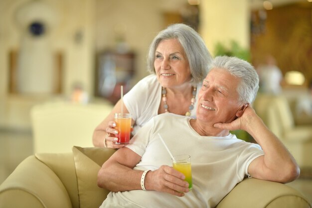 Felice coppia senior che beve cocktail in hotel