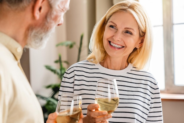 Felice coppia senior che beve vino a casa