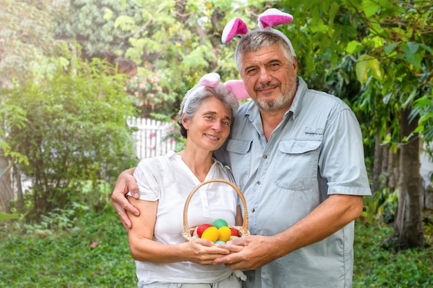 Felice coppia senior con uova di Pasqua nel carrello all'aperto