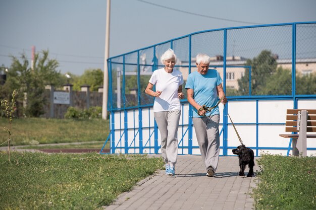 Felice coppia senior in esecuzione con il cane