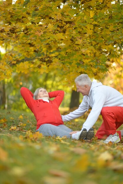 Felice coppia senior in forma che si esercita nel parco autunnale