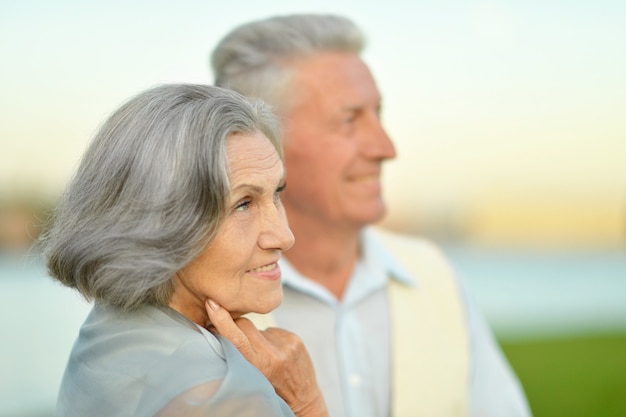 Felice coppia senior vicino al fiume in estate, sfondo sfocato