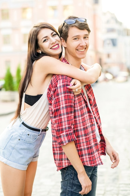 Felice coppia sorridente che si diverte in strada in estate
