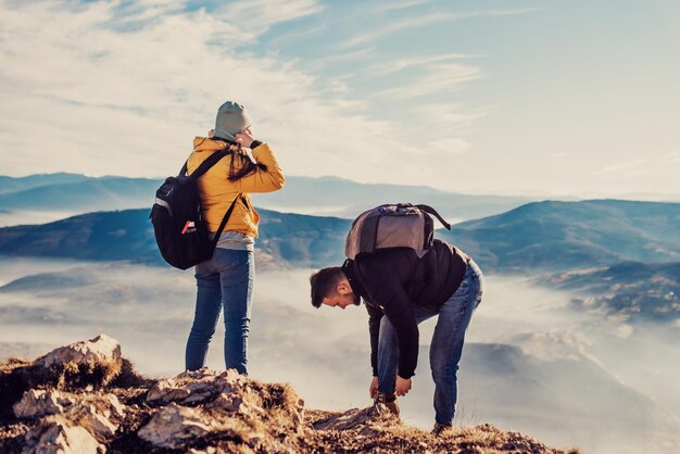 Felice coppia uomo e donna turista in cima alla montagna durante un'escursione in estate