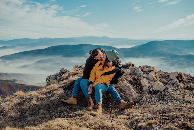 Felice coppia uomo e donna turista in cima alla montagna durante un'escursione in estate
