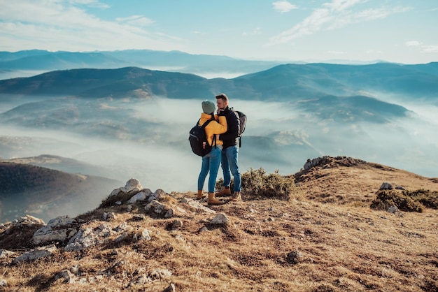 Felice coppia uomo e donna turista in cima alla montagna durante un'escursione in estate