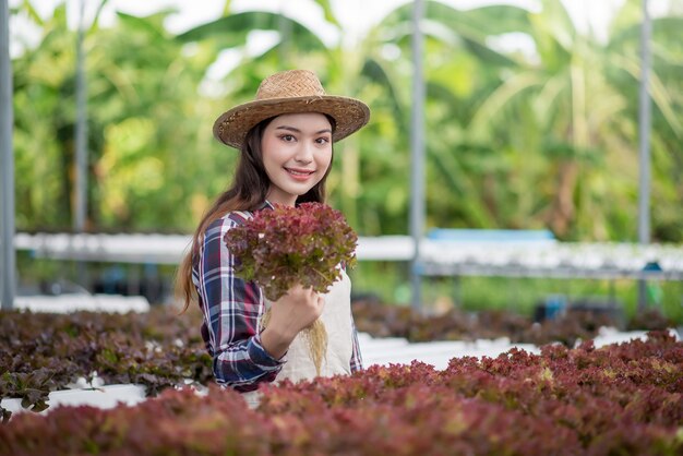 Felice di giovane donna asiatica all'azienda agricola di verdure