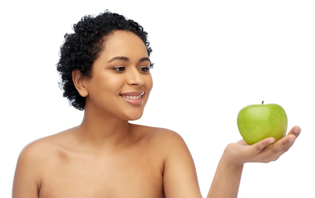 felice donna afroamericana con una mela verde in mano