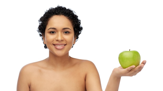 felice donna afroamericana con una mela verde in mano