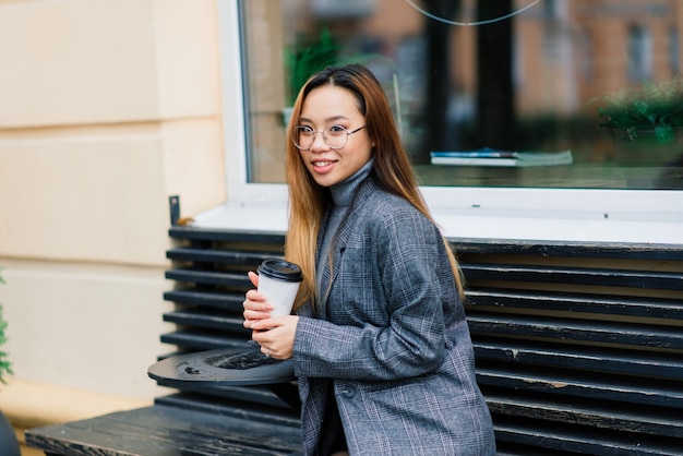 Felice donna asiatica sulla strada della città