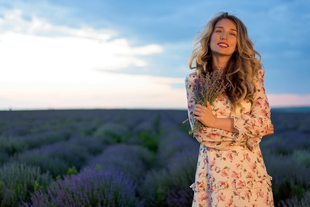 Felice donna bionda in campo di lavanda