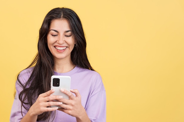 Felice donna caucasica sorridente mentre si utilizza il cellulare