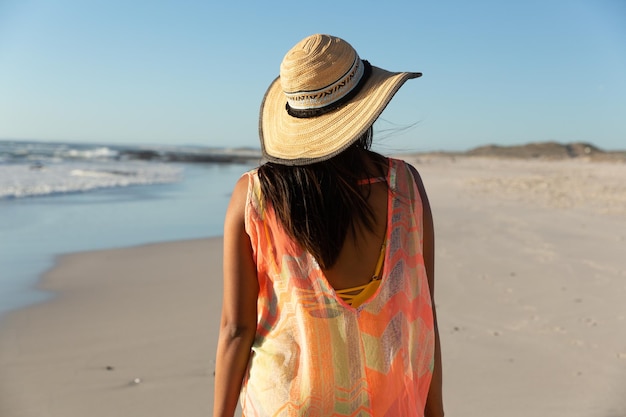 Felice donna di razza mista in vacanza al mare che guarda lontano. sano tempo libero all'aria aperta in riva al mare.