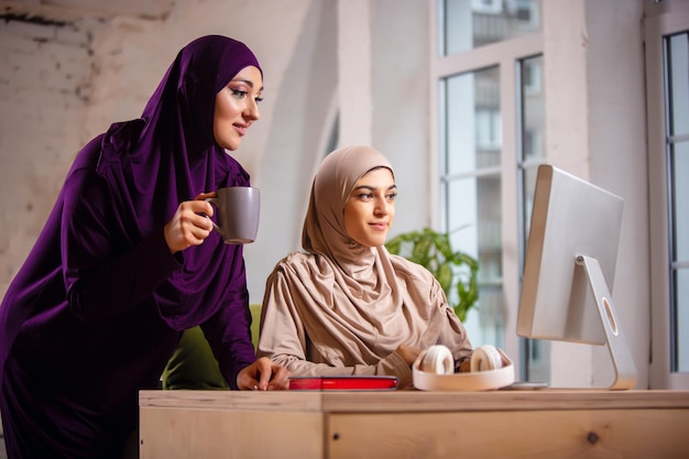 Felice donna musulmana a casa durante la lezione online.