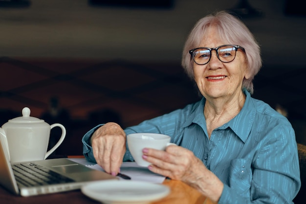 Felice donna senior documenti lavoro foglio di carta e penna stile di vita inalterato