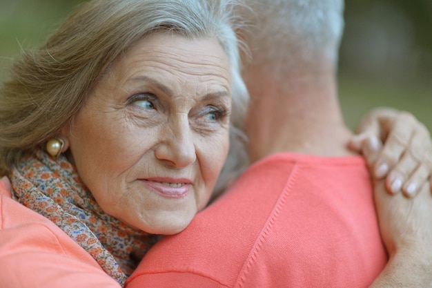 Felice donna senior e uomo nell'abbraccio del parco