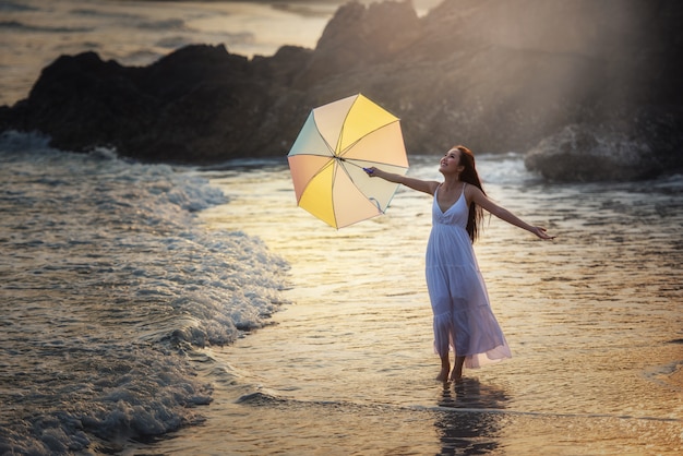 Felice donna spensierata godendo il bellissimo tramonto sulla spiaggia