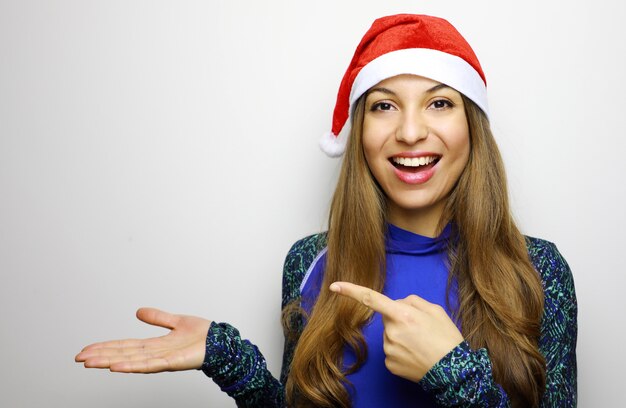 Felice donna sportiva con cappello santa mostrando e puntando il dito