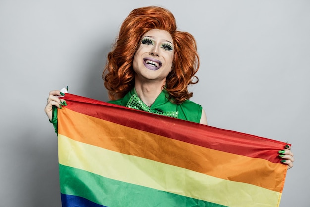 Felice drag queen azienda bandiera arcobaleno concetto Lgbtq Focus sul viso