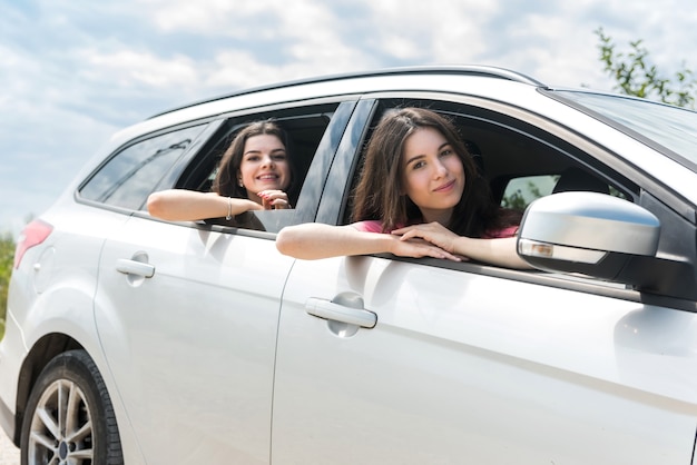 Felice due giovane donna che viaggia in viaggio in auto