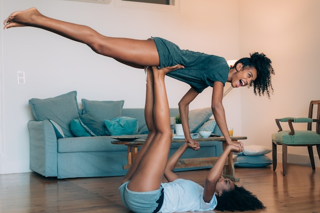 Felice due giovani donne di colore rilassato a casa giocando