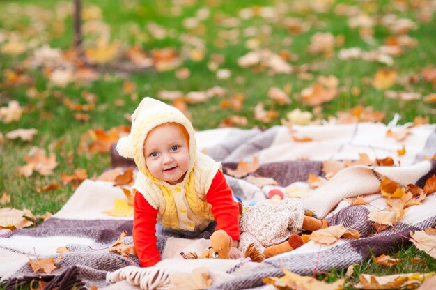 Felice e bambina sta giocando nel parco d'autunno.