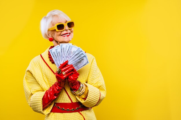 Felice e divertente vecchia signora con vestiti alla moda ritratto su sfondo colorato Nonna giovanile con concetti di stile stravaganti sull'anzianità di vita e sugli anziani