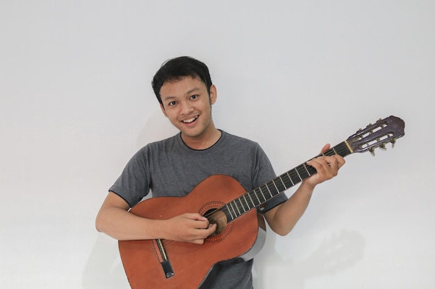 Felice e sorriso Giovane musicista asiatico con la chitarra