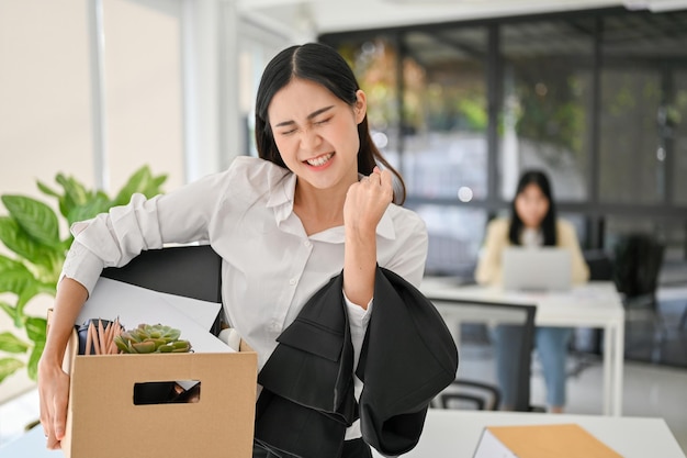 Felice ed eccitato giovane impiegato femminile asiatico che celebra le sue dimissioni