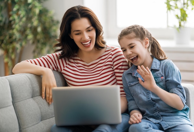 Felice famiglia amorevole Giovane madre e figlia ragazza utilizzando il computer portatile