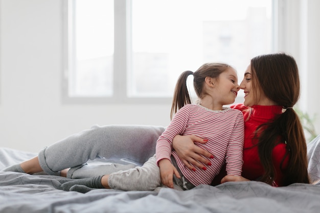 Felice famiglia amorevole. Madre e figlia figlia bambina giocando e abbracciando.