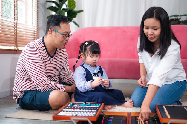 Felice famiglia asiatica sorridente insieme a casa