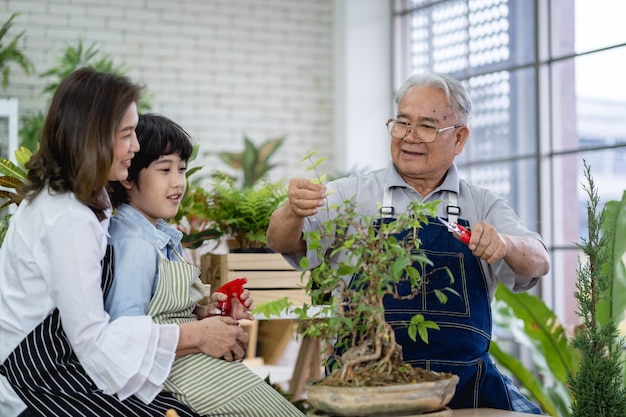 Felice famiglia che fa giardinaggio insieme nel giardino nonno nipote e donna che si prendono cura della natura