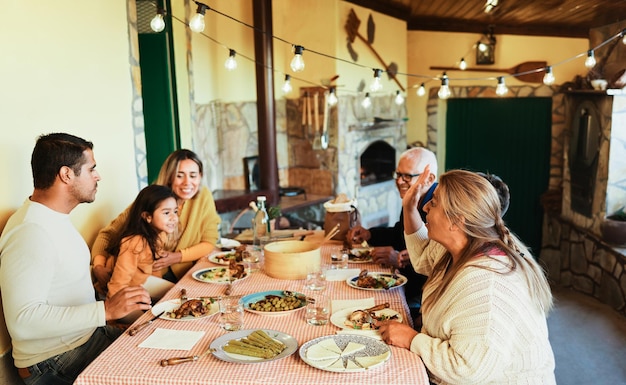 Felice famiglia latina che si diverte a mangiare insieme a casa - Focus sulla faccia della nonna