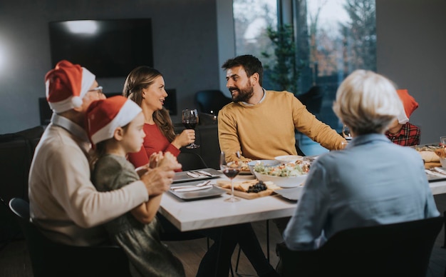 Felice famiglia multigenerazionale che festeggia il nuovo anno a tavola a casa