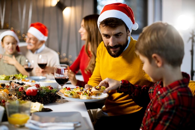 Felice famiglia multigenerazionale che festeggia il nuovo anno a tavola a casa