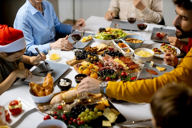 Felice famiglia multigenerazionale che festeggia il nuovo anno al tavolo pieno di cibo a casa