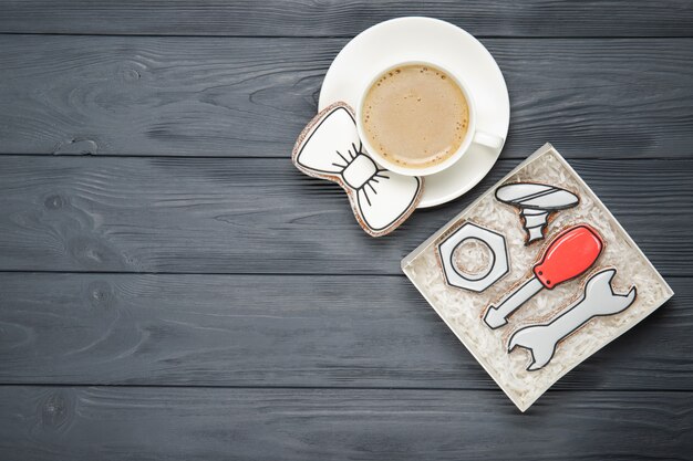 Felice festa del papà concetto. Biscotti e tazza di caffè saporiti su fondo di legno